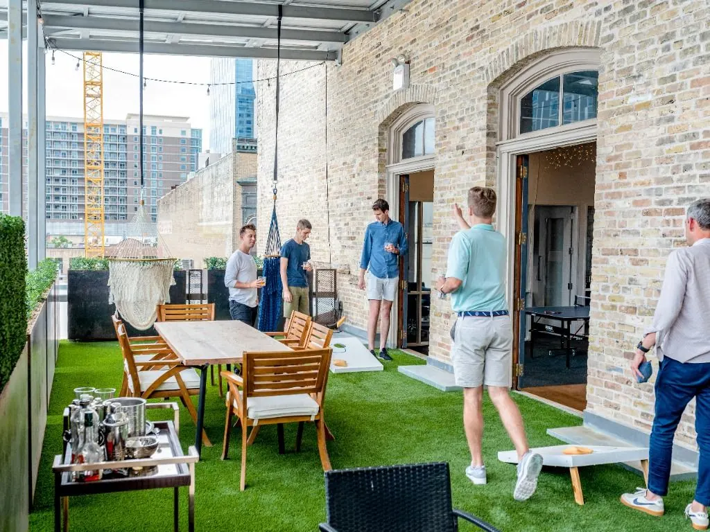 Des collègues échangent sur une terrasse de séminaire au pied d’immeubles